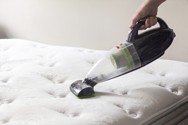 vacuuming baking soda from mattress to clean