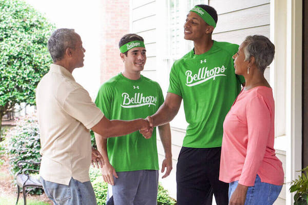 bellhops shaking hands with a customer