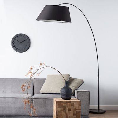 black arc floor lamp over grey sofa