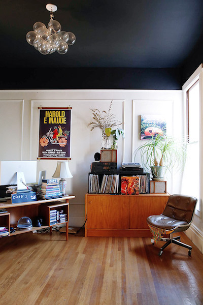 living room with black ceiling and white walls and light wood floors