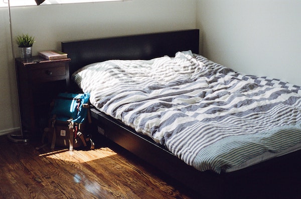 low bed with black frame and striped comforter