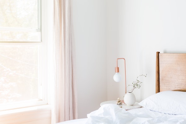 clean white guest bedroom with open windows