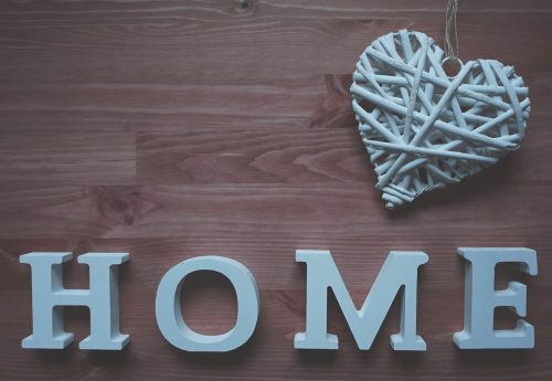 white wooden home letters with a wicker heart