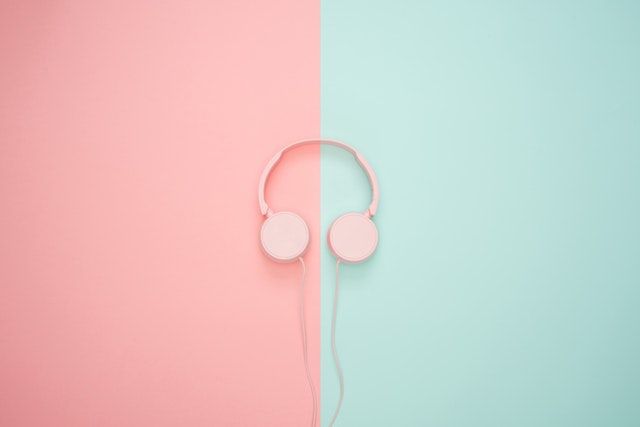 a pair of pink headphones by a blue and pink background