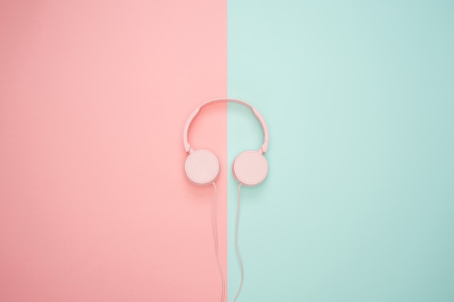 a pair of pink headphones by a blue and pink background