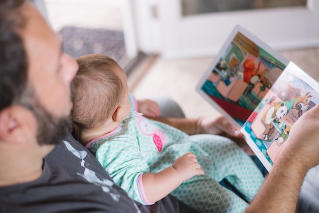 a parent reading to an infant