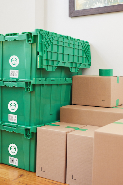 MakeSpace bins stacked by the wall with paper boxes