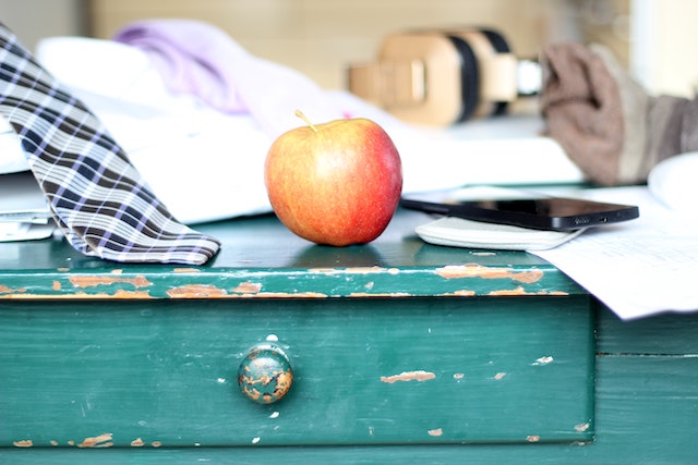 a nightstand with an apple on top of it