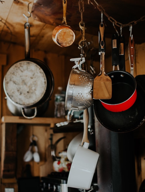 kitchen utensils hanging above a counter