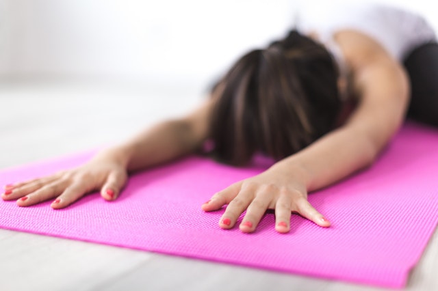 a girl stretching on a yoga mat