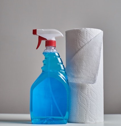 bottle of an all-purpose cleaner and a roll of paper towel