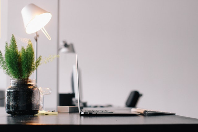 a work desk with a table lamp