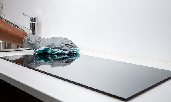 a hand cleaning a kitchen counter