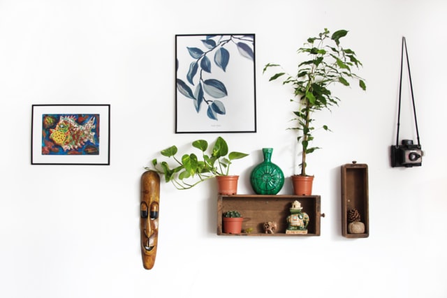 Paintings on the wall with accent decor of masks and vases