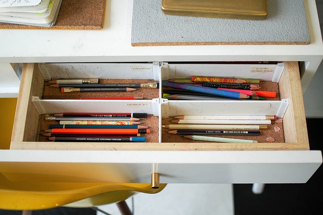 a drawer with pencils and paint brushes neatly organized