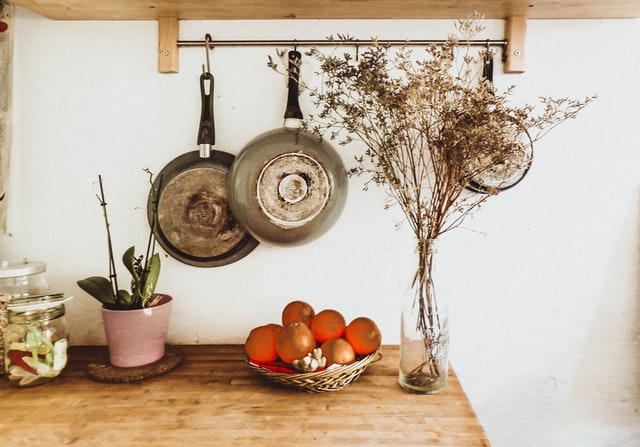 A beautiful kitchen countertop with pans hanging on hooks 