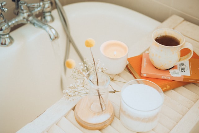 bath tub with candles and lowers on the side