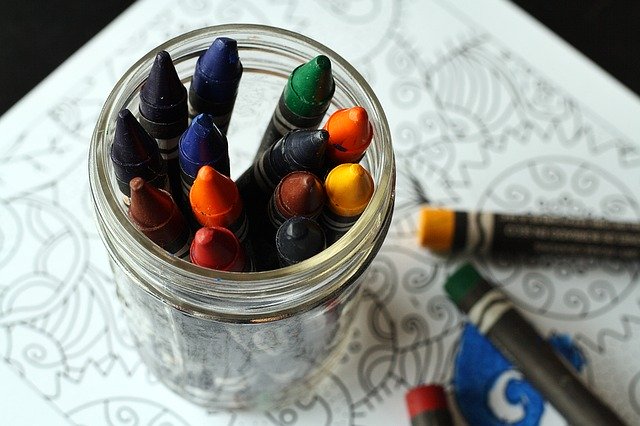 A cup of crayons on a painting book