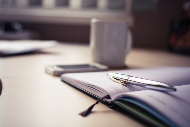 a pen laying across a diary