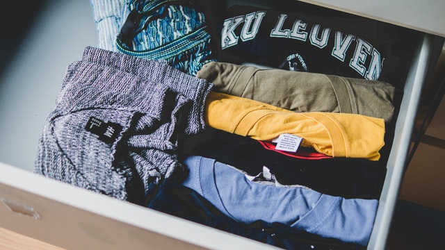 a drawer full of folded t-shirts and sweaters