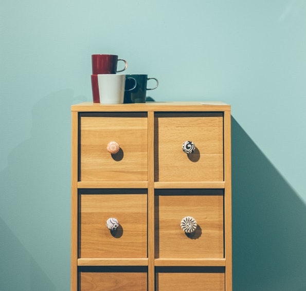 A small wooden cabinet with tiny drawers