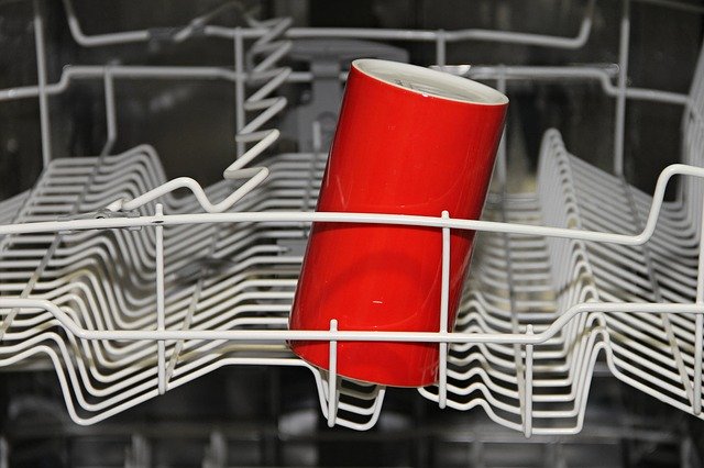 A glass filled with vinegar inside a dishwasher