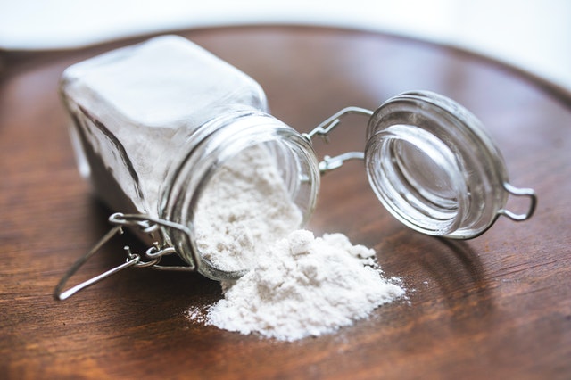 A jar of baking soda on a wooden table