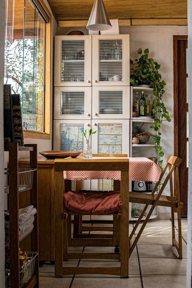 A kitchen cabinet by a small dinning nook 