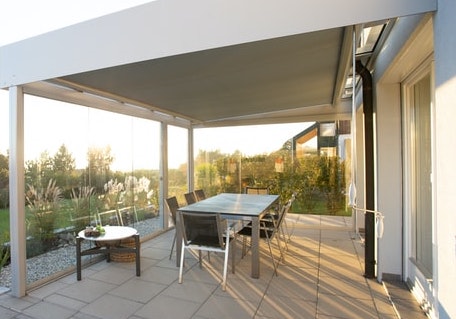 A terrace with a dinning table and lots of plants