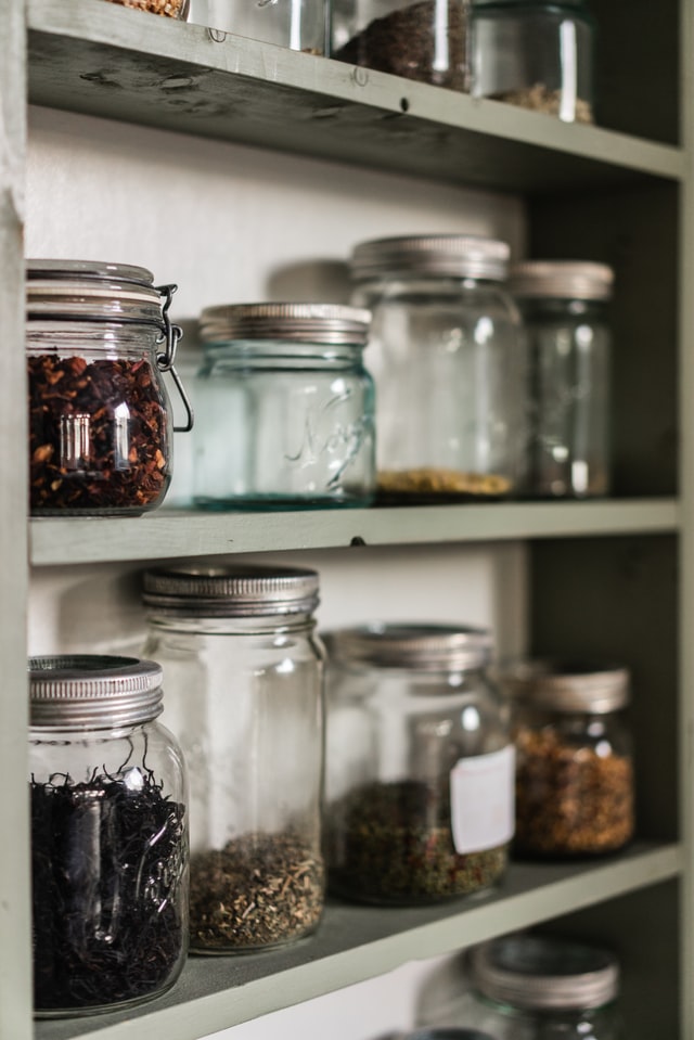 Shelves of pantry with glass jars on them