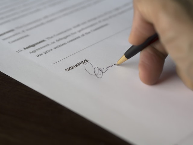 A hand signing a contract