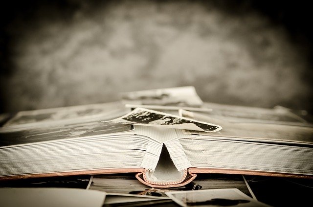 A black and white photo album with photos on top of it