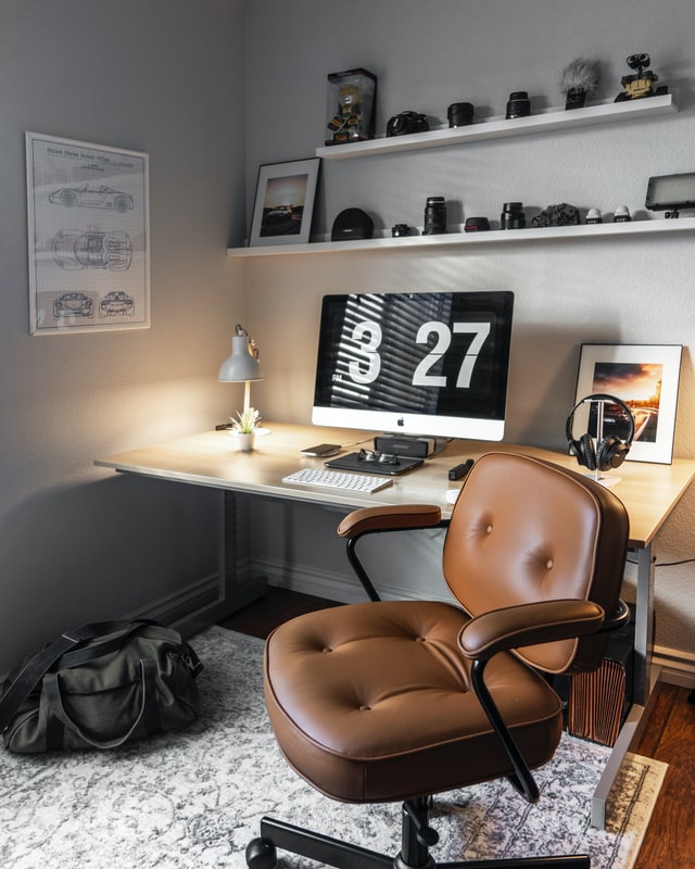 A leather tufted chair against a clean organized home desk