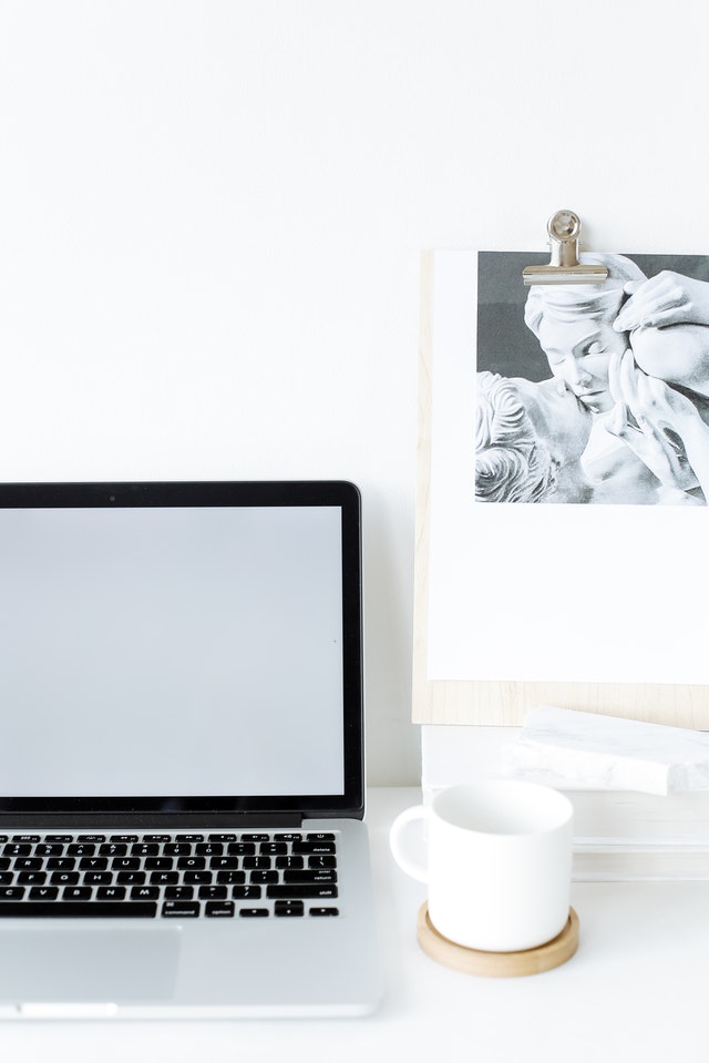 A home office with a coffee mug and a laptop