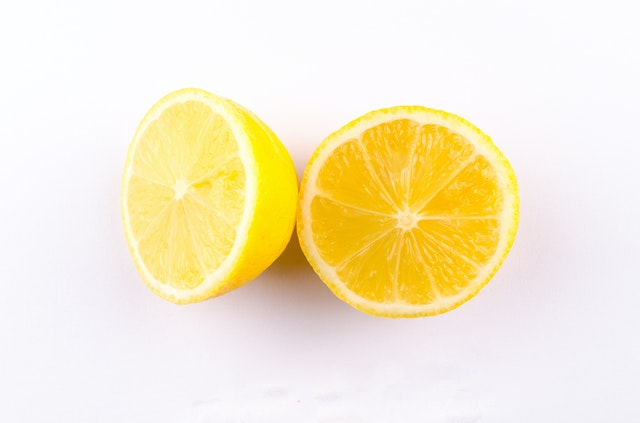 A lemon cut into two against a white background.