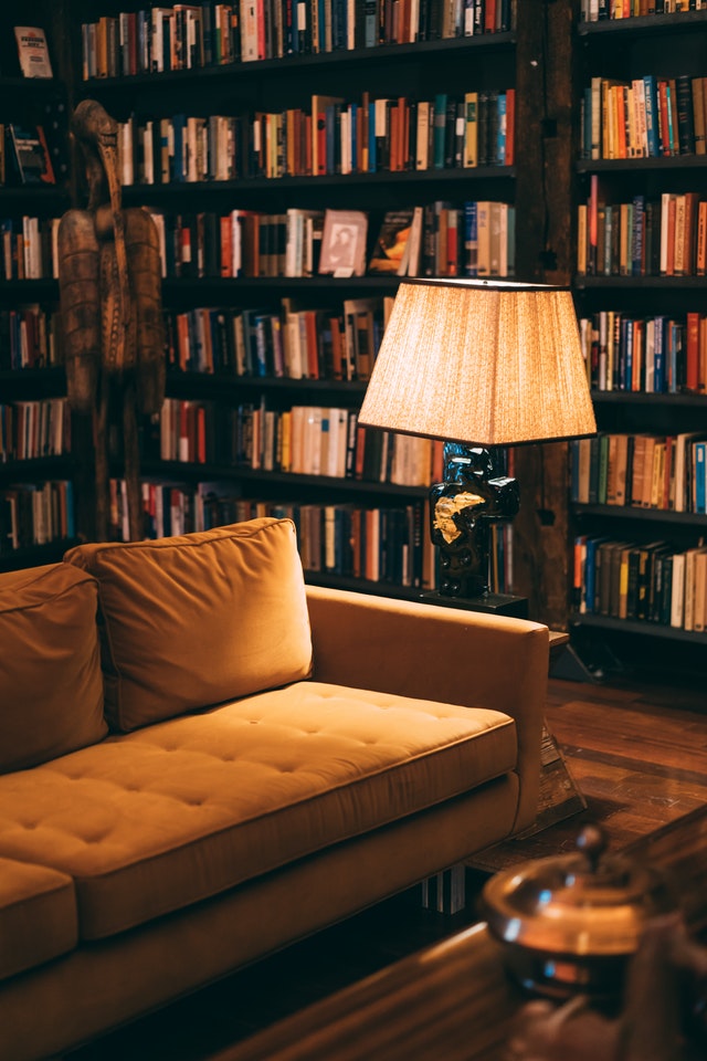 A reading nook surrounded by books on wall to ceiling shelves