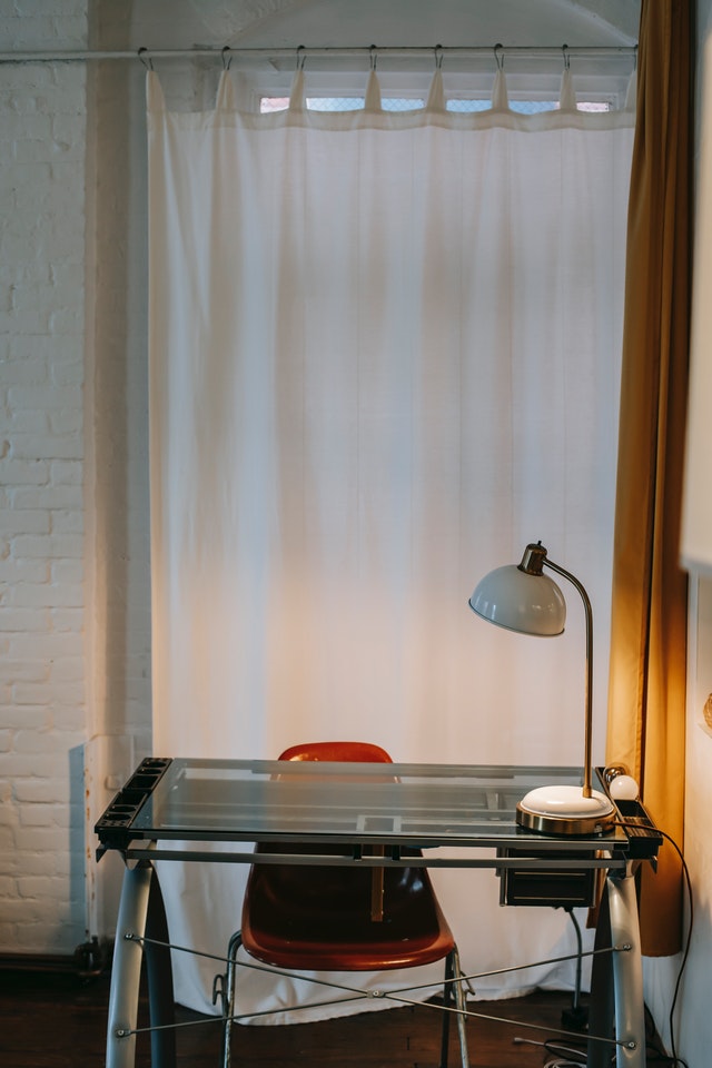 A white curtain sections off a work desk