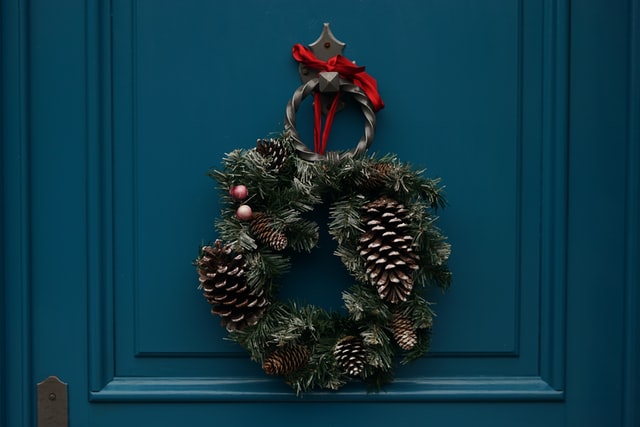 A festive wreath on a teal door