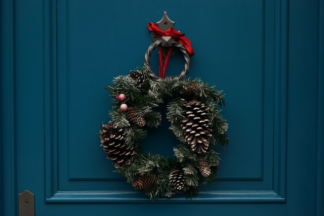 A festive wreath on a teal door