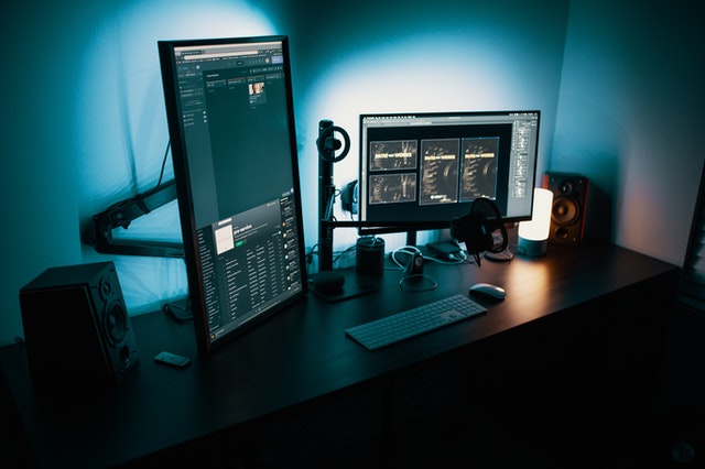 Three work screens in a dark room