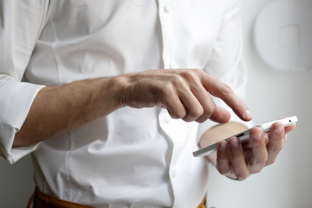 A man scrolling through his smartphone.
