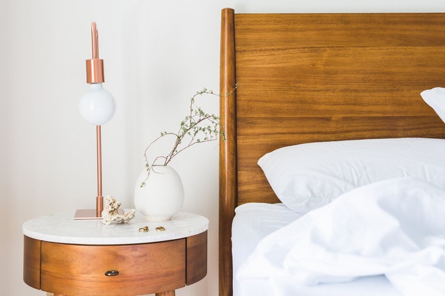 A wooden bed headboard and a nightstand next to it.