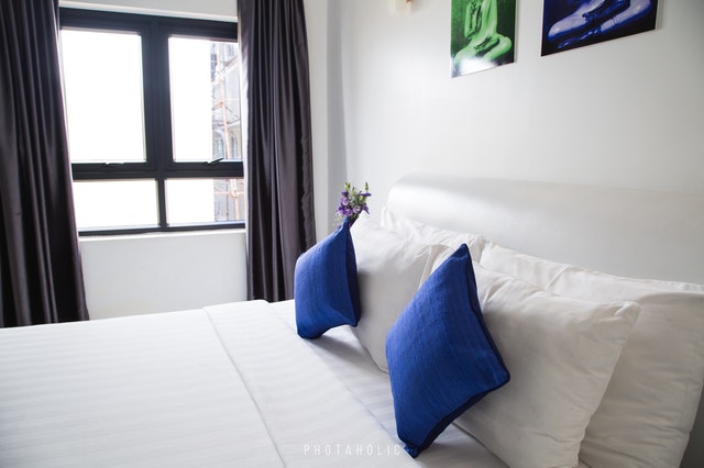 Blue pillows on a well organized bed