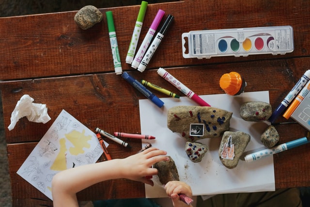 A child painting rocks with markers. 
