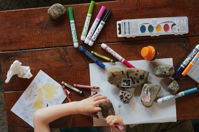 A child painting rocks with markers.