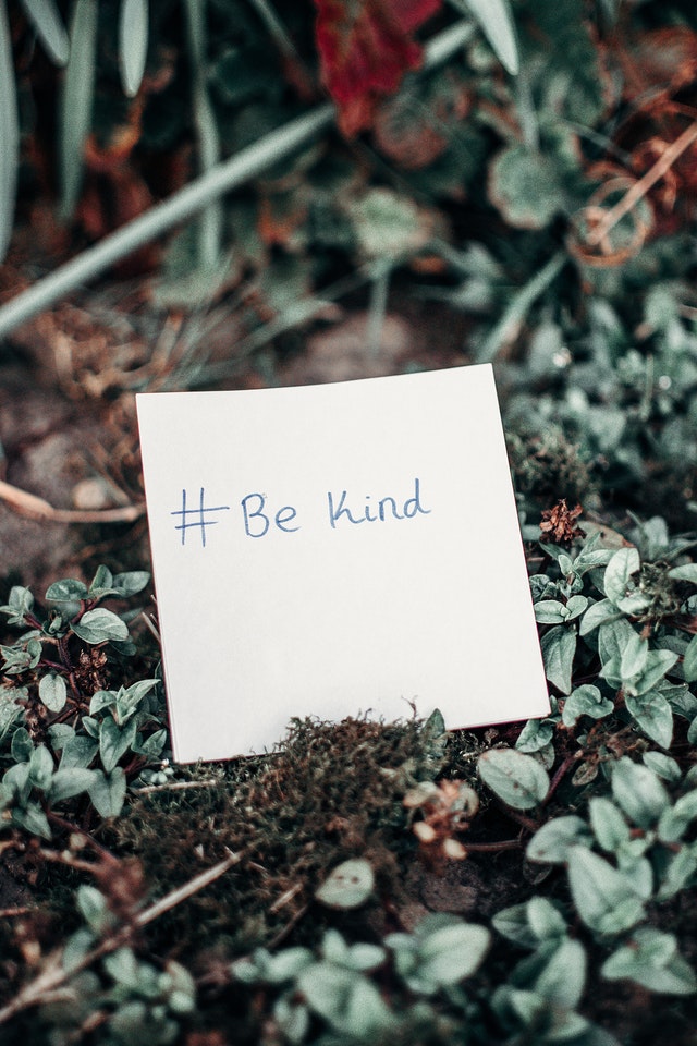 The words 'be kind' written on a post-it note 