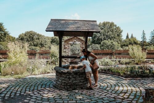 mother and son looking into water well