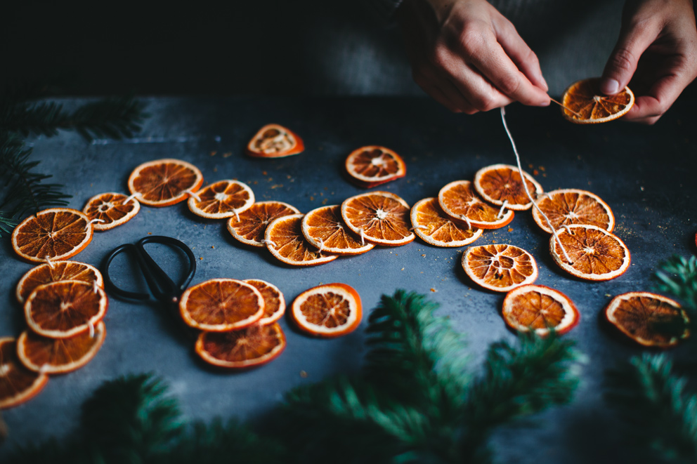 Stringing up dried orange garland is a simple way to decorate your apartment for the holidays.