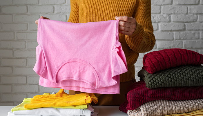 woman separating winter and spring clothes