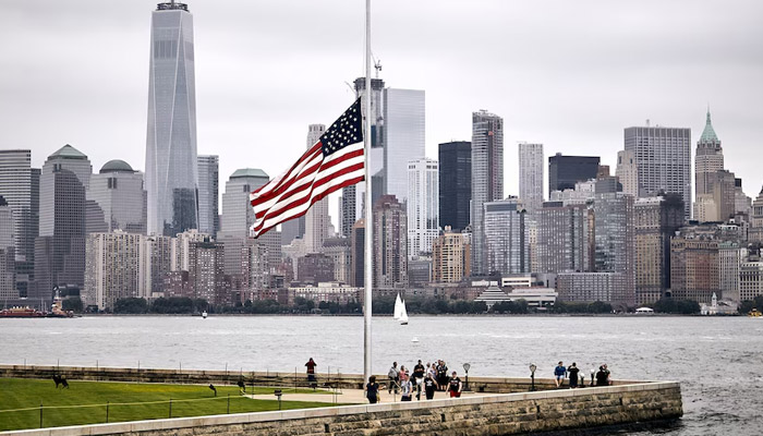 US flag in a park on the Manhattan skyline background